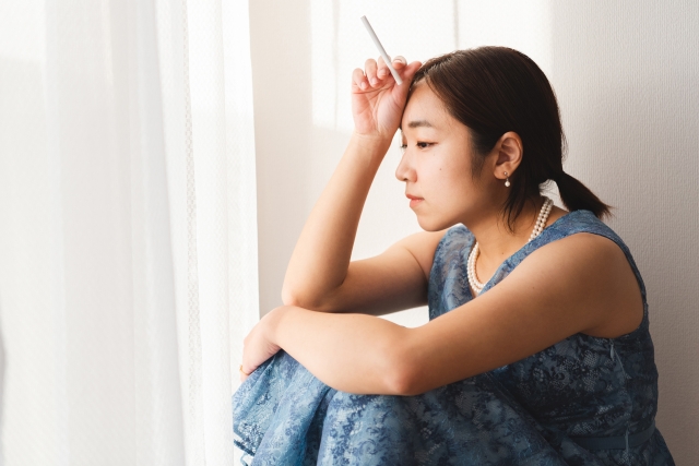 タバコを吸おうか迷っている女性