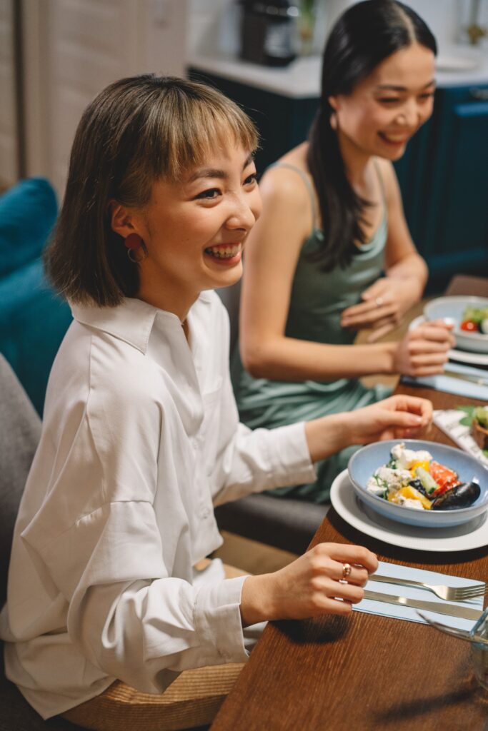 友達と笑顔で食事する女性